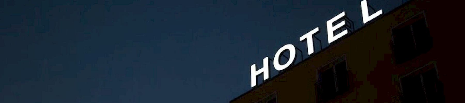 A building with "HOTEL" sign in white letters under a dim, dark sky is visible.